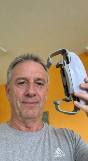 Un hombre sostiene el abre-tarros eléctrico y muestra sus dos brazos laterales